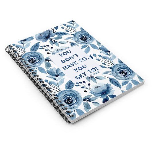 Notebook with blue floral design and motivational quote on a white background