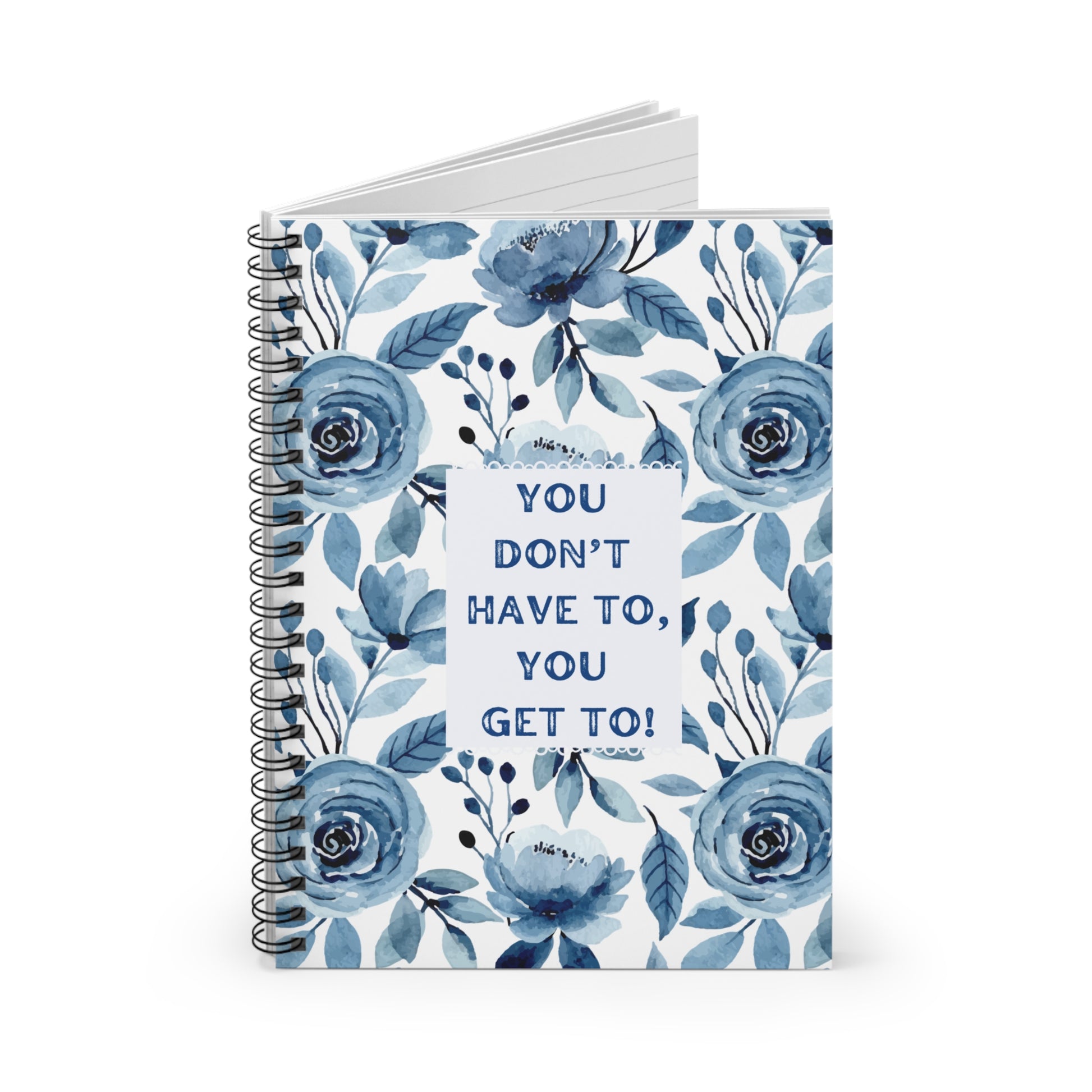 Slightly opened notebook with blue floral design and motivational quote on a white background