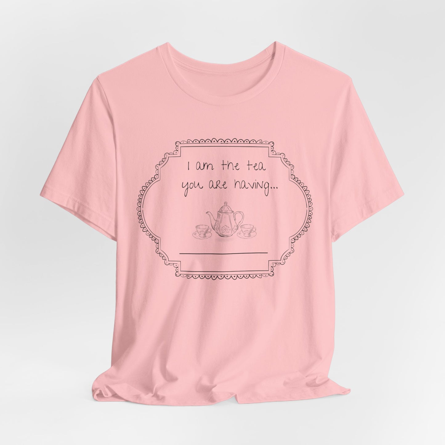 Pink t-shirt with a graphic and text on a light gray studio background