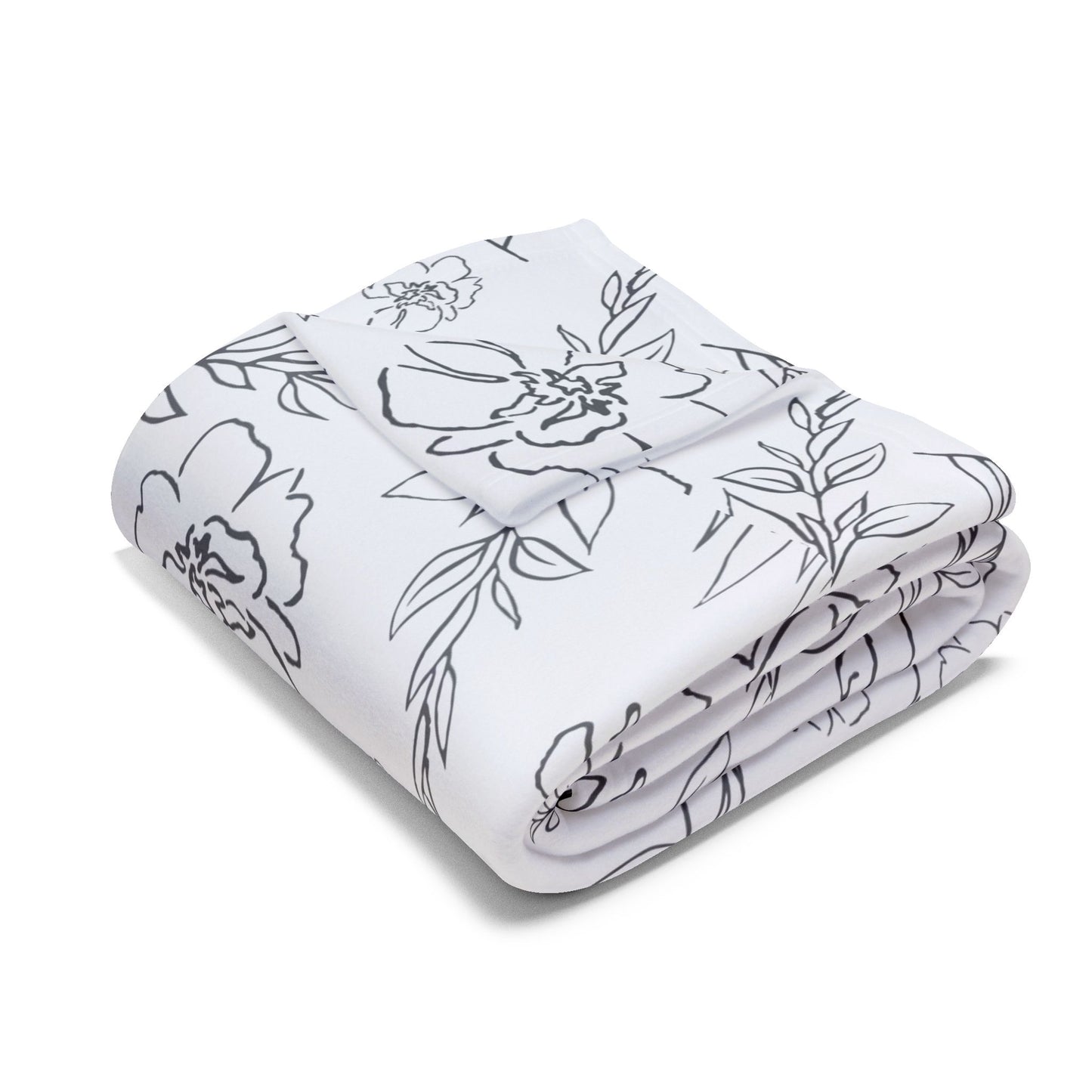 Folded white blanket with black floral pattern on a white background