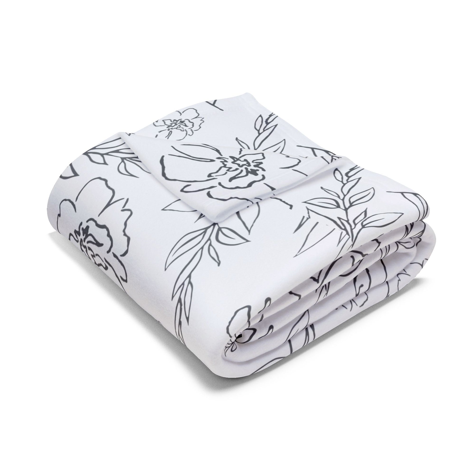 Folded white blanket with black floral pattern on a white background