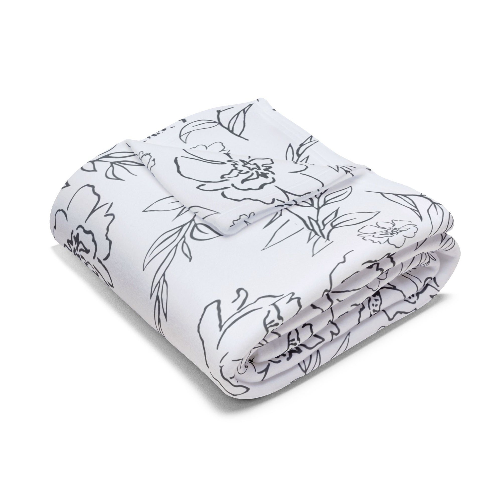 Larger size blanket with folded corner and with black floral pattern on white background