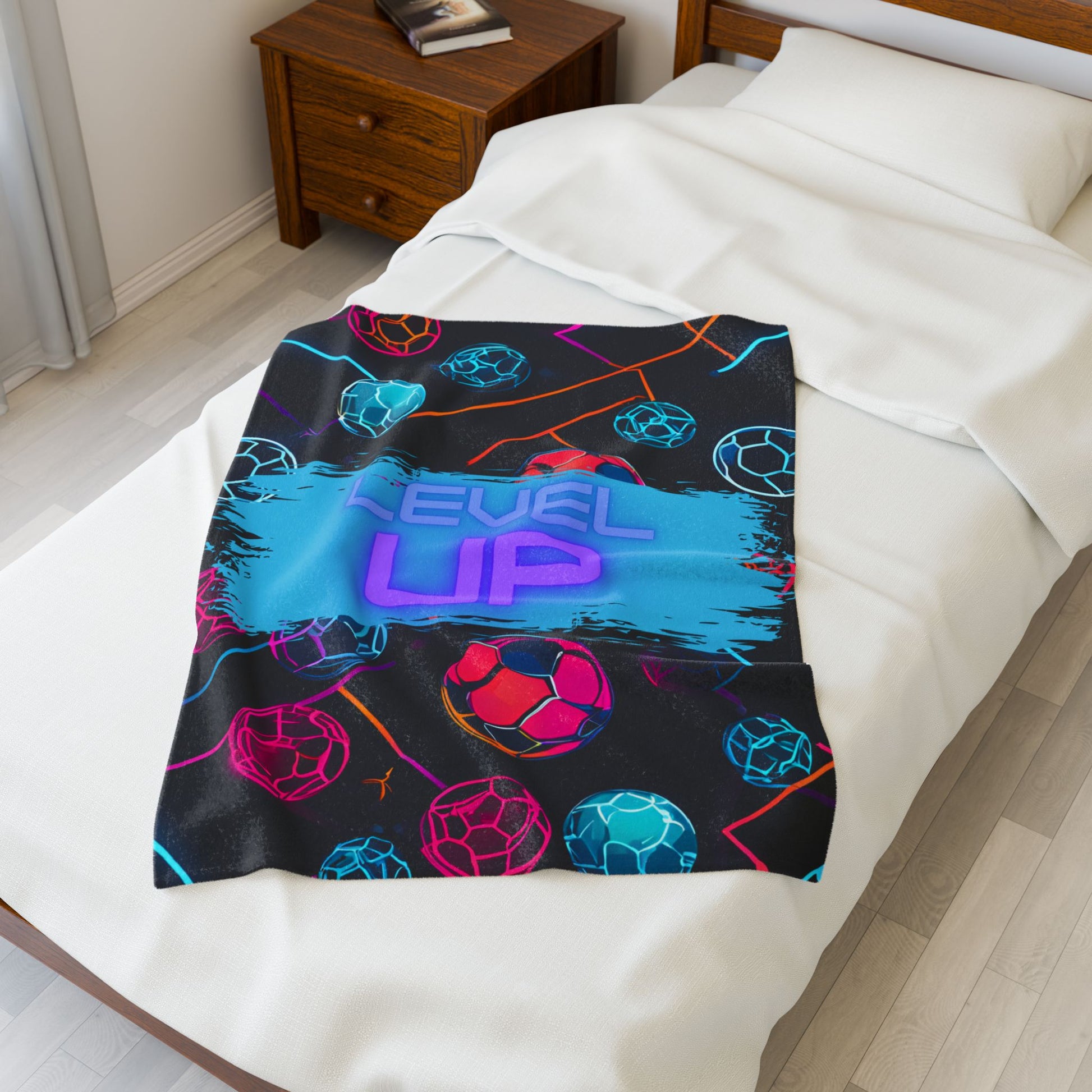 Smaller size colorful blanket with 'Level Up' text on a bed in a bedroom setting